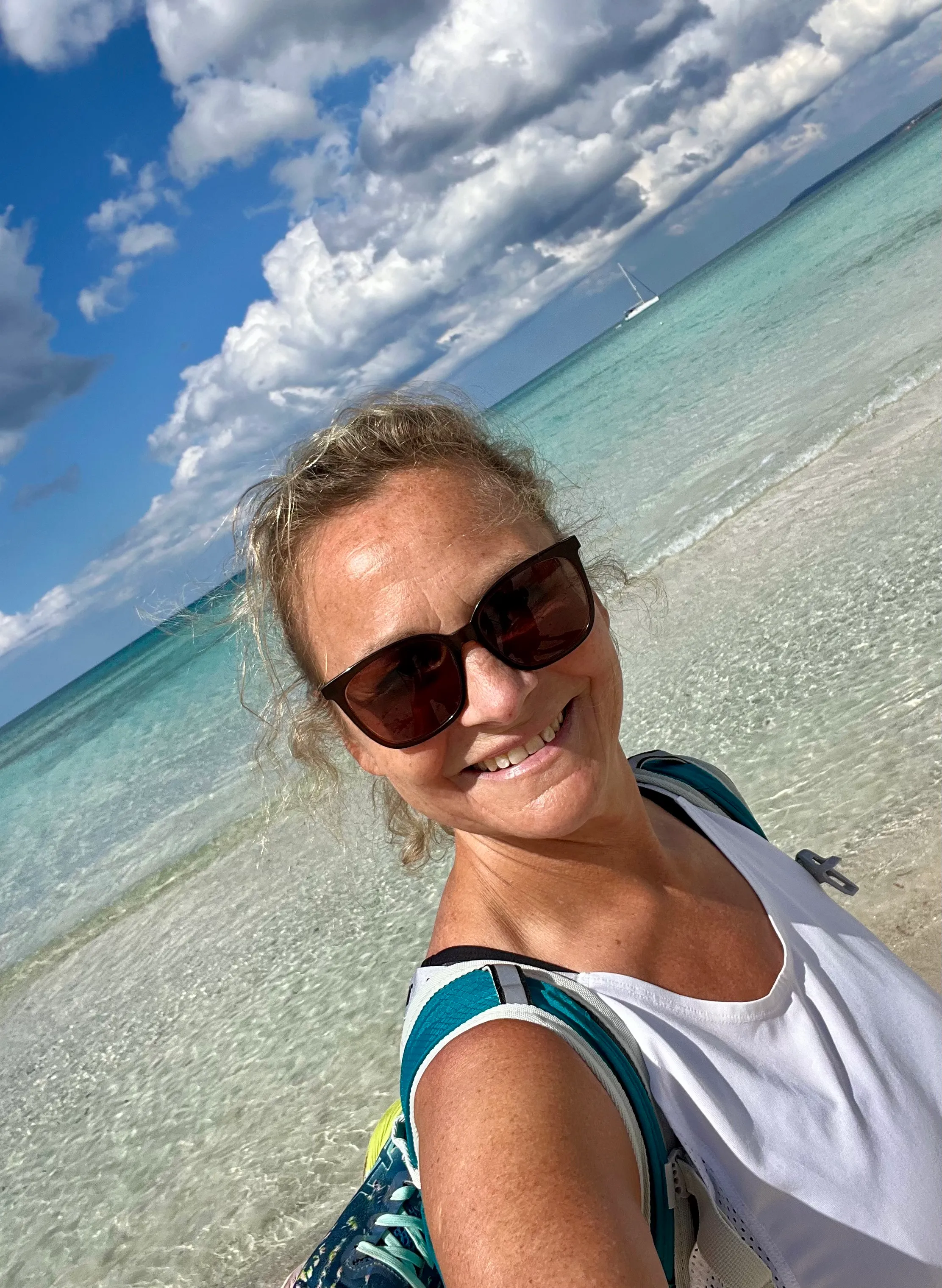 Frau mit Sonnenbrille im türkisfarbenen Meer