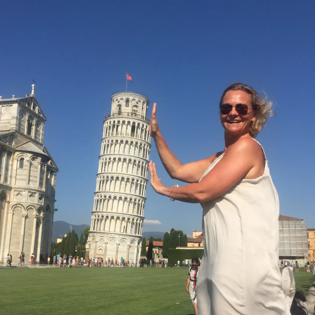 Frau hält schiefen Turm von Pisa