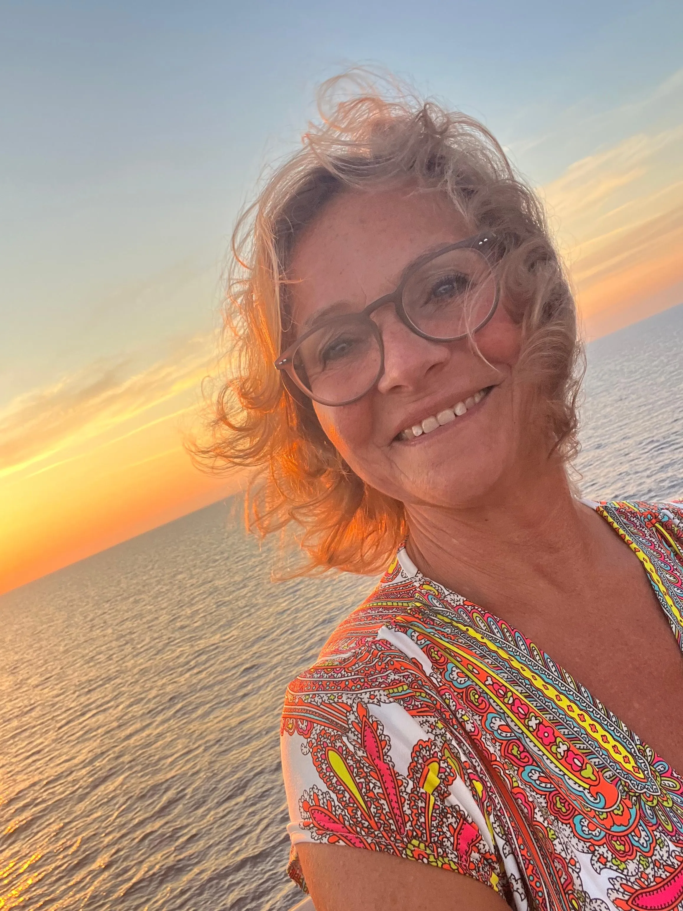 Frau an Bord eines Schiffes bei Sonnenuntergang