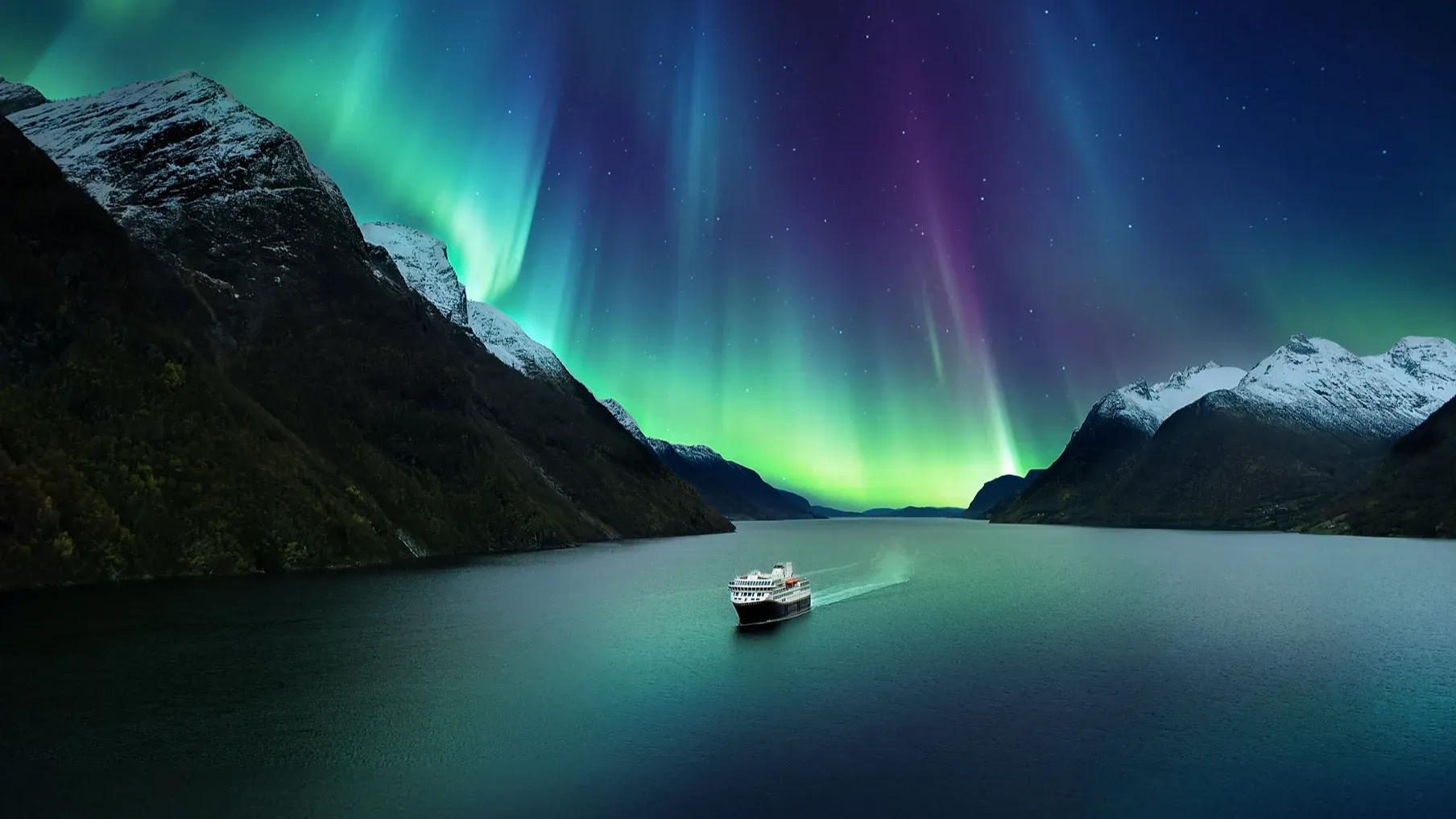 Zwei Personen sitzen in einem Whirlpool auf einem Schiff mit Blick auf einen Fluss und bewaldete Berge