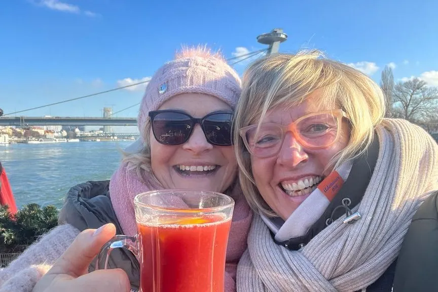 Zwei Frauen lachen in die Kamera und haben eine Tasse in der Hand