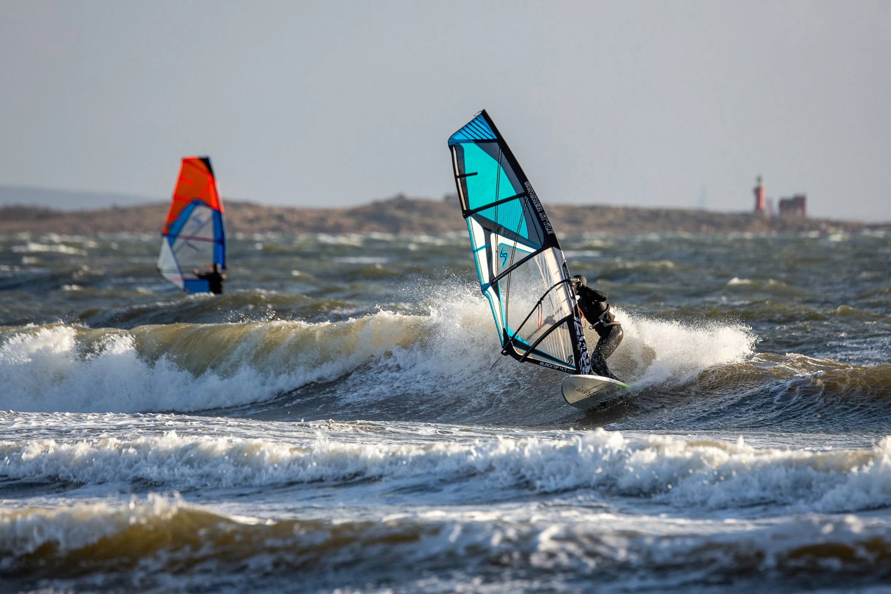 Zwei Kitesurfer surfen auf der rauen Nordsee